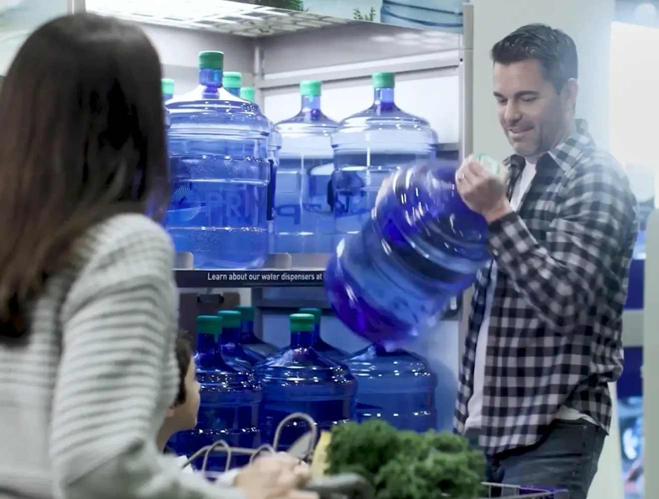 Man lifts a 5 gallon blue water jug from a shelf in a store.