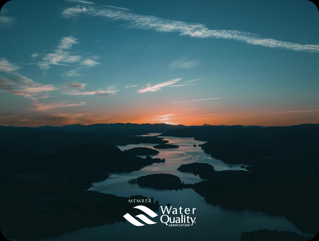 Sunset over river with Member of Water Quality Association logo