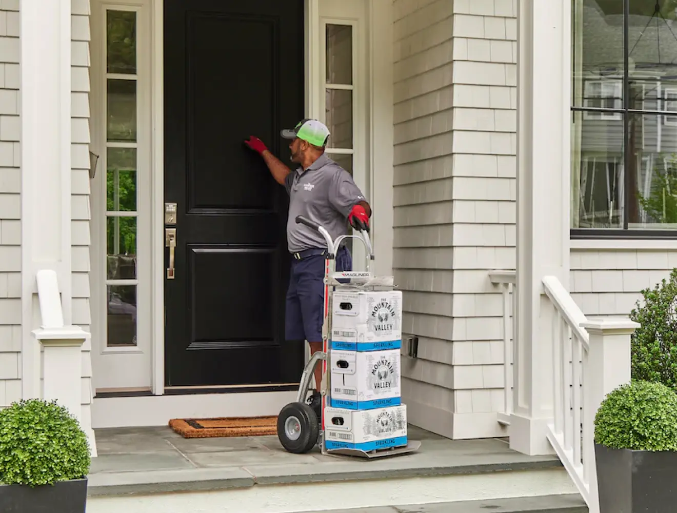 Delivery Man with three cases Mountain Valley Spring Water Delivery