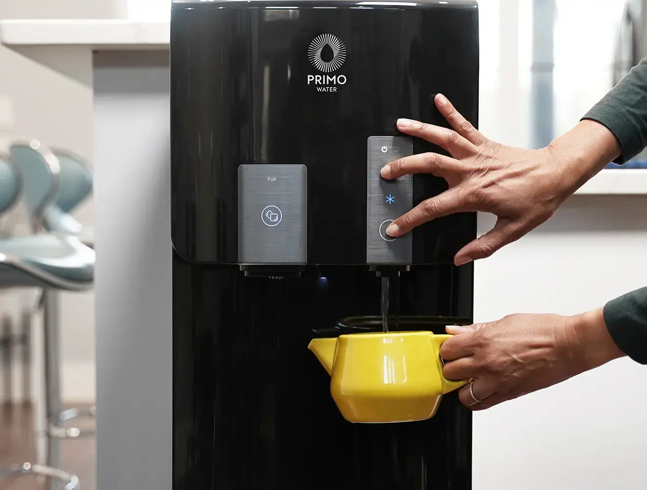 Customer filling a teapot with Primo water dispenser