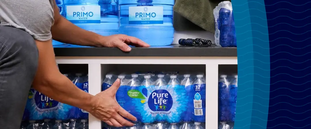 Person organizing Pure life bottled water packs on a shelf, with larger water containers above labeled "Primo Water"