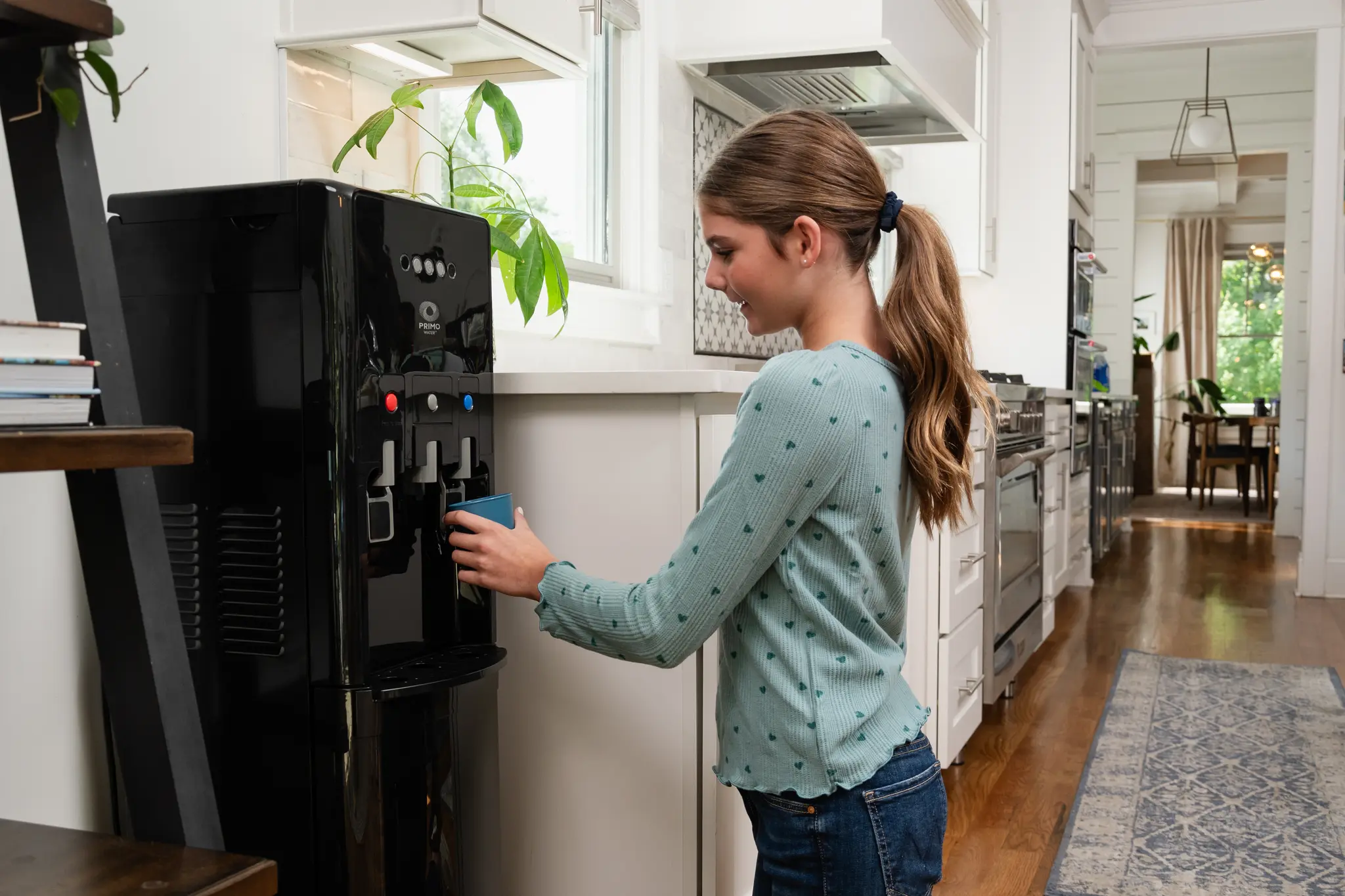 A young girl using a Primo Water Dispenser at home