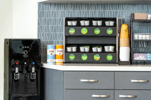 A Breakroom stocked by Primo Commercial Services, with a Water Dispenser, Green Mountain Coffee, Coffee Creamer and Sugar.