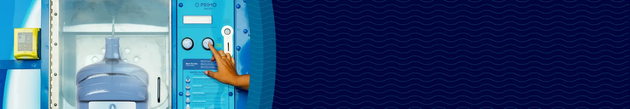A person presses a button on a primo water machine with a filled water jug inside, against a dark blue patterned background.