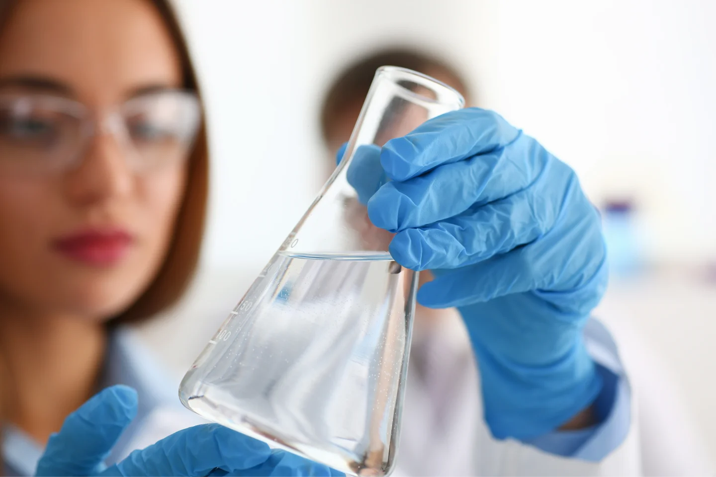 Woman scientist with water in beaker
