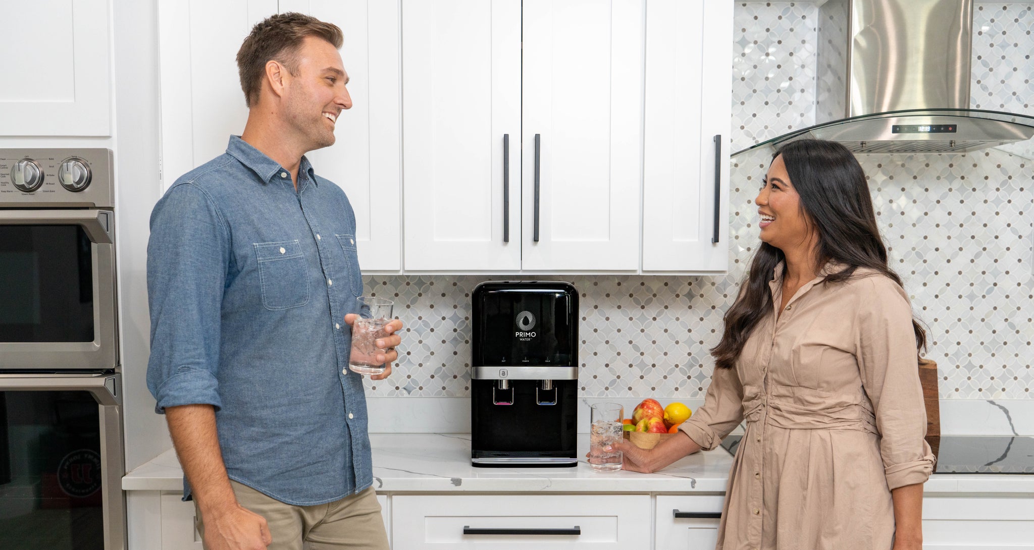 A couple drinking filtered water from a Primo Countertop Water Filtration System